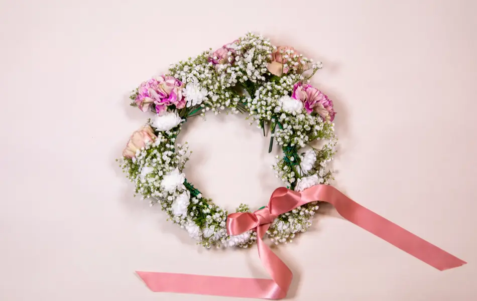 Ferdiglaget blomsterkrans med rosa sløyfe