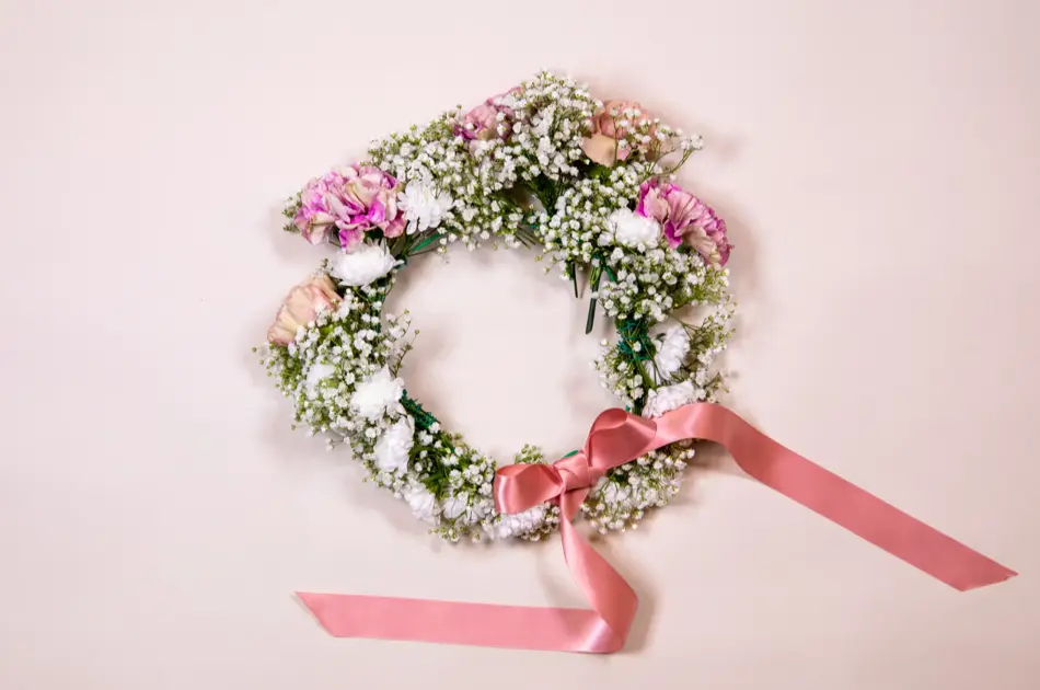 Ferdiglaget blomsterkrans med rosa sløyfe