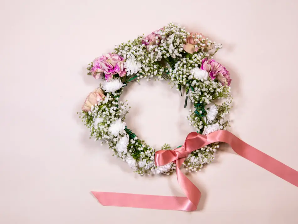 Ferdiglaget blomsterkrans med rosa sløyfe