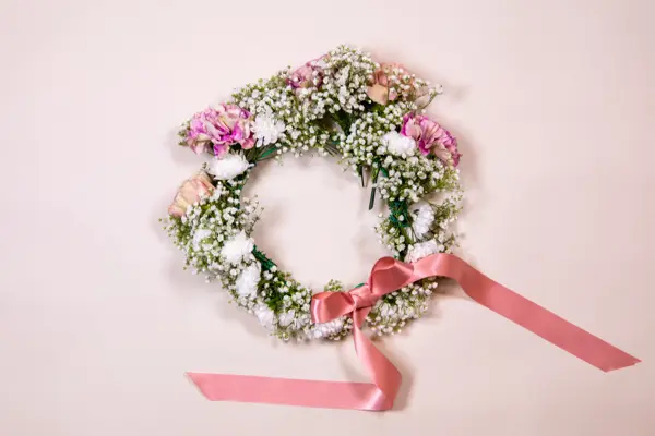 Ferdiglaget blomsterkrans med rosa sløyfe