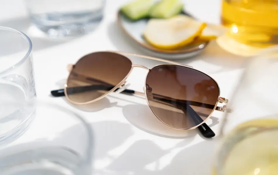 Pilotbriller med brunt glass på et bord