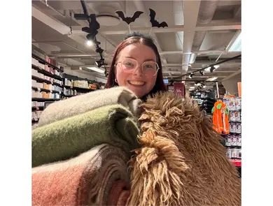 Kvinne med flaggermus-ører holder tekstiler