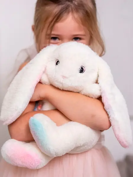 Jente som klemmer en kaninbamse