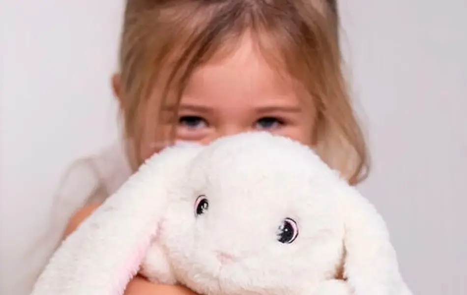 Jente som klemmer en kaninbamse