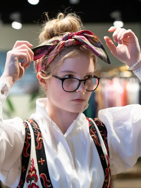 Hos Embla, jente prøver tørkle i håret