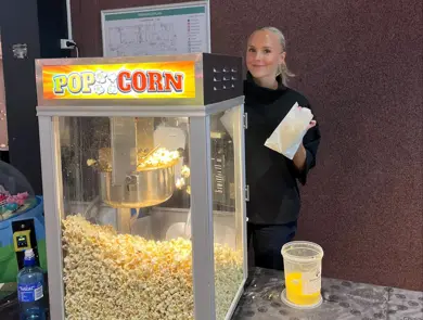 Dame står ved popcornmaskin