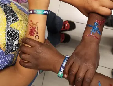 Bilde av barns hender med glitter tattoveringer på armene