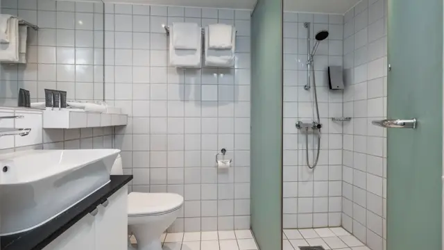 Bad med servant, speil, toalett, og dusj.