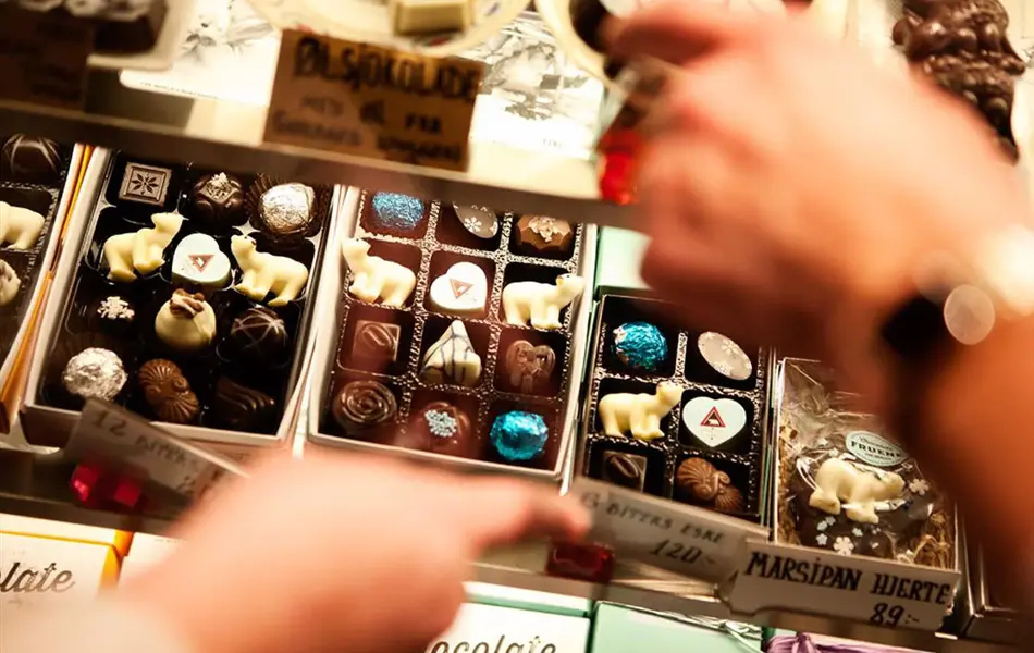 To hender som peker på konfekter