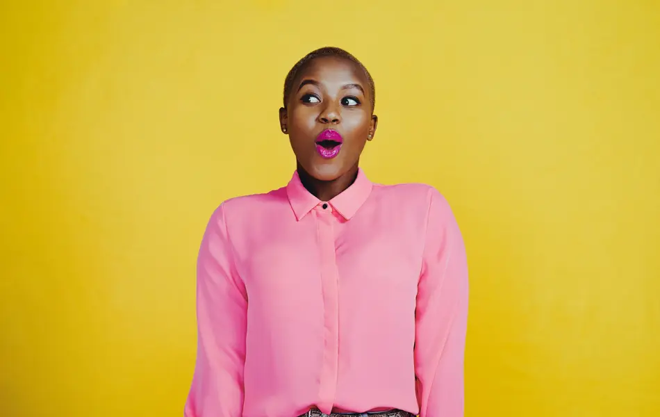 Cropped shot of an attractive young woman looking curious and surprised in studio against a yellow background