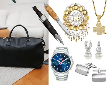 Sort weekendbag står på et stuegulv, bunadskniv, sølje, kjede med firkløver-anheng, øredobber med perle, sølv mansjettknapper, klokke med blå urskive.