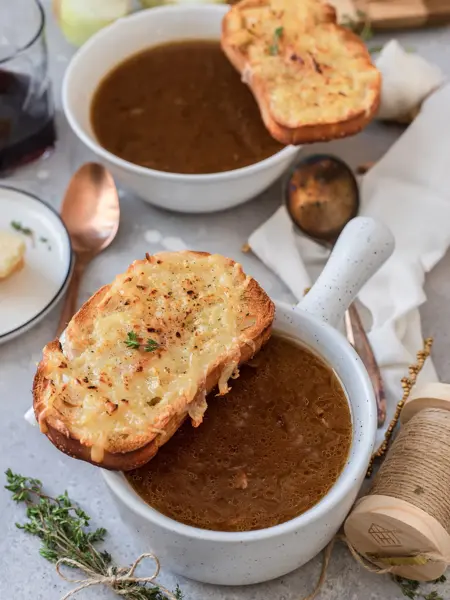 To skåler med løksuppe og brød