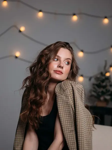 Dame poserer med brun rutete blazer over en svart fløyelskjole