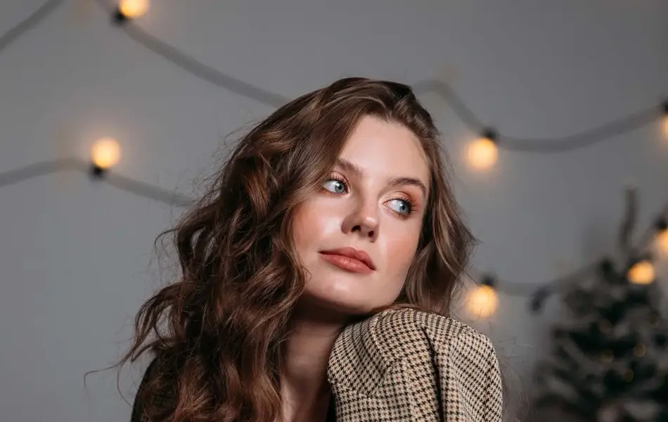 Dame poserer med brun rutete blazer over en svart fløyelskjole