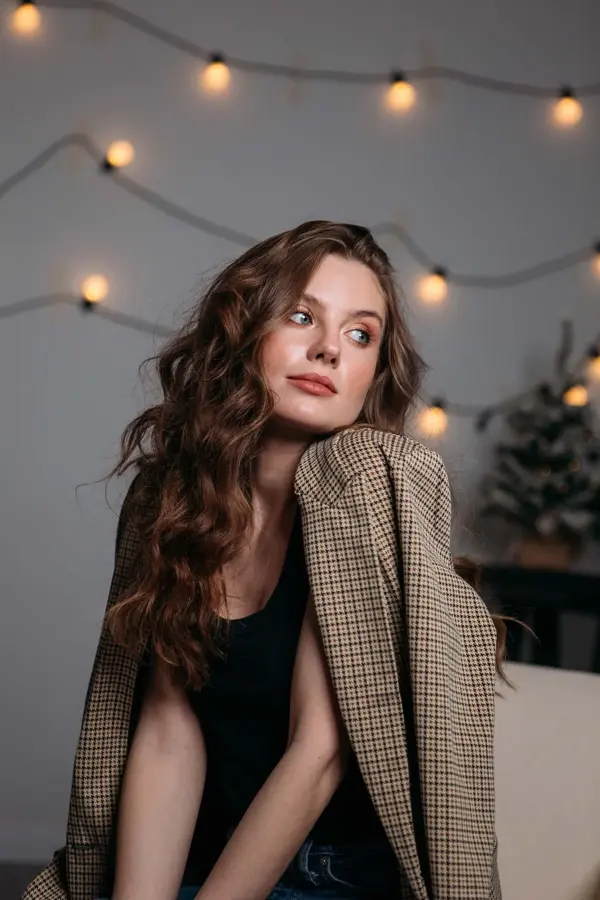 Dame poserer med brun rutete blazer over en svart fløyelskjole