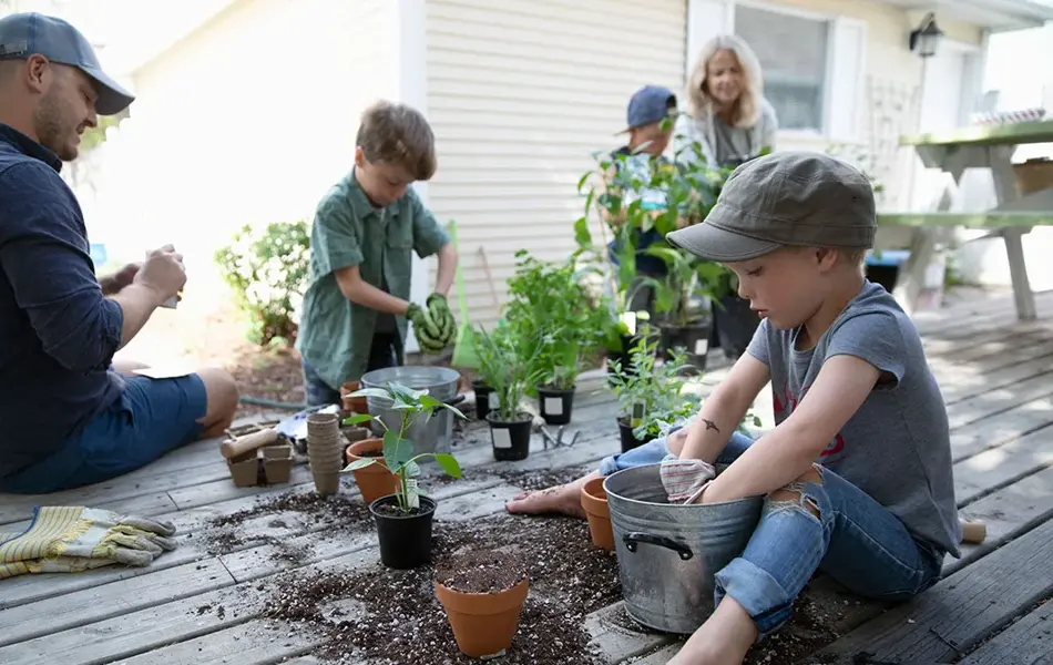 Familie på fem omplanter potter i hagen