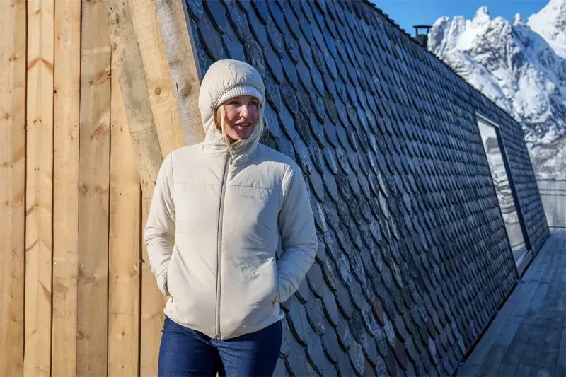 Dame i boblejakke med hvitkledde fjell i bakgrunn