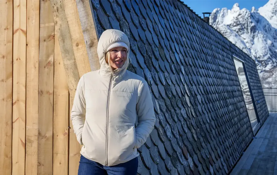 Dame i boblejakke med hvitkledde fjell i bakgrunn