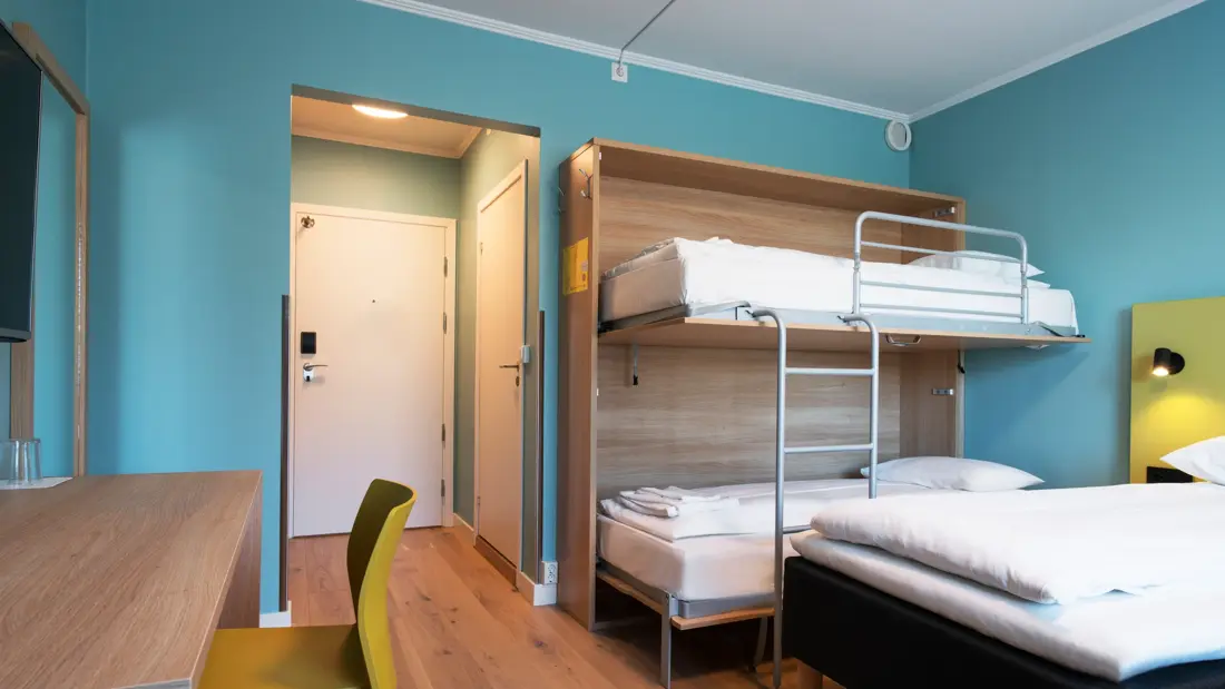 Dobbeltseng, køyeseng og skrivebord i familierom på Thon Hotel Gardermoen