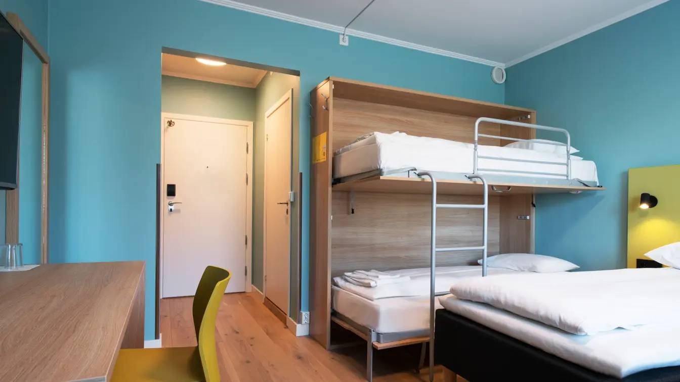 Dobbeltseng, køyeseng og skrivebord i familierom på Thon Hotel Gardermoen