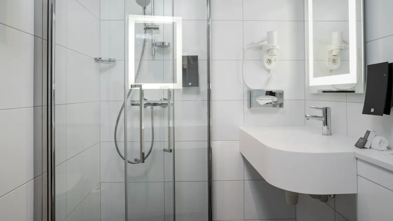 Vask og speil med led lys rundt. Hårtørker og dusj på bad i enkeltrom på Thon Hotel Bristol Bergen