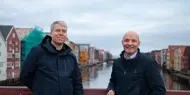 Trond Are Martinsen og Ståle Dullum står på Gamle Bybro med bryggerekka i bakgrunnen. Portrett tatt ifm. oppussing av Kjøpmannsgata 15 i Trondheim.