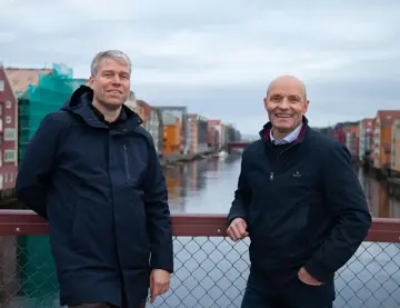 Trond Are Martinsen og Ståle Dullum står på Gamle Bybro med bryggerekka i bakgrunnen. Portrett tatt ifm. oppussing av Kjøpmannsgata 15 i Trondheim.