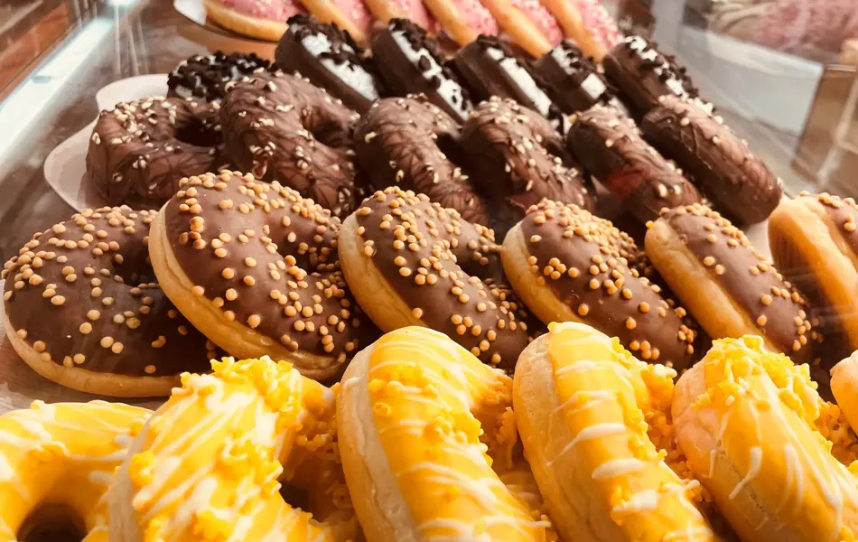 Bilde av mange forskjellige donuts på et fat.