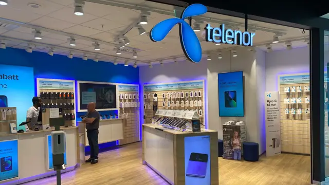 innendørs butikk med blå skilt og reoler på gulv og vegg