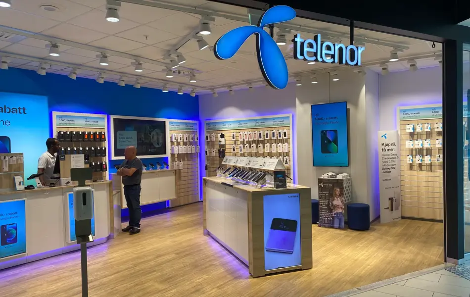 innendørs butikk med blå skilt og reoler på gulv og vegg