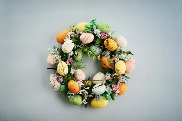 Decoration from easter eggs in shape of circle on painted wooden background