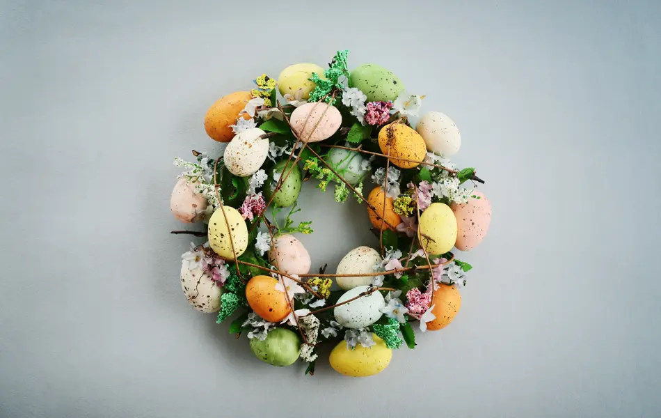 Decoration from easter eggs in shape of circle on painted wooden background