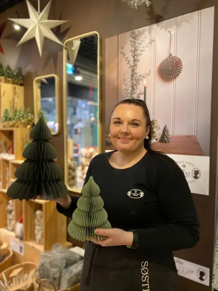 ansatt hos søstrene grene viser julepynten to grønne papirtrær