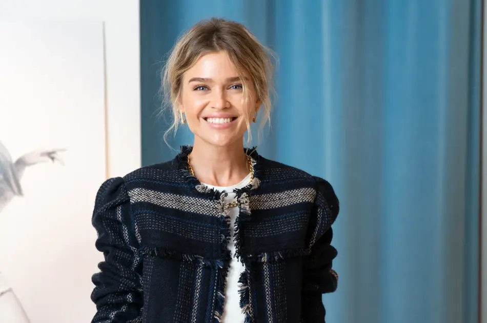 Dame i jakke foran blå vegg