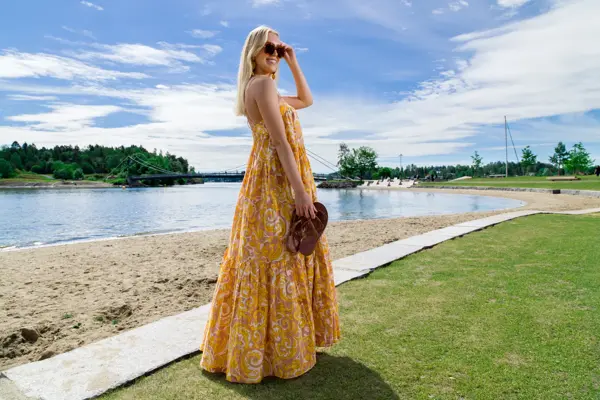 Jente med lyst hår og gul kjole på en strand