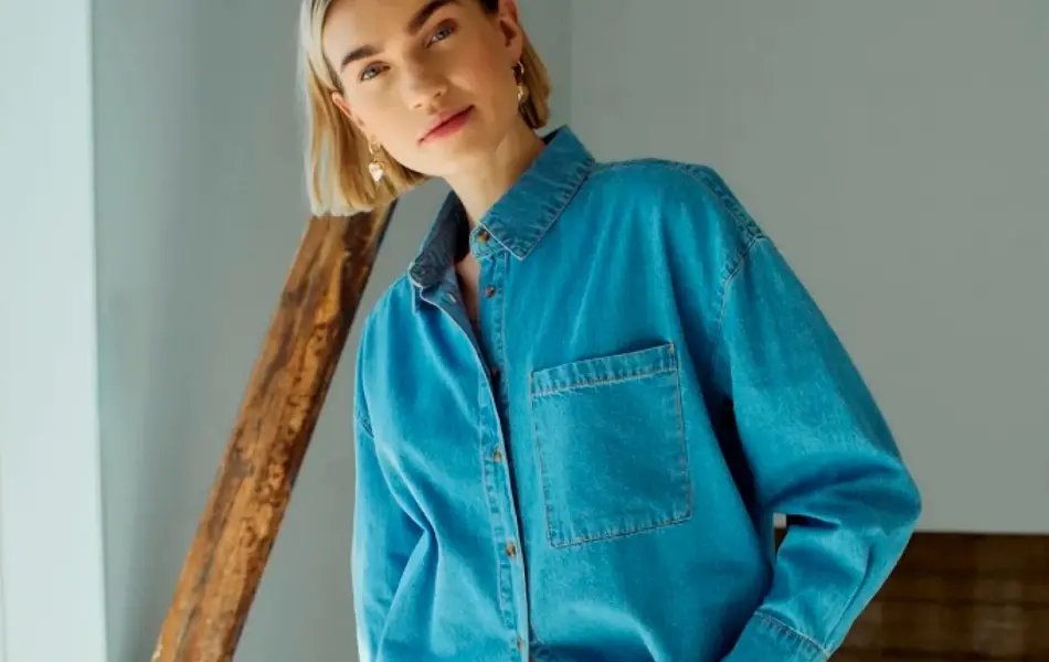 Damemodell i jeansskjorte og jeans.