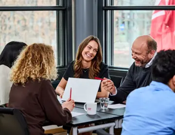 Bilde av fire personer rundt et bord, tatt på en konferanse holdt på Thon Hotel
