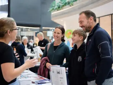 En utställare berättar om sin verksamhet för besökare