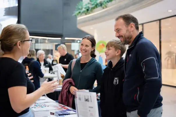 En utställare berättar om sin verksamhet för besökare
