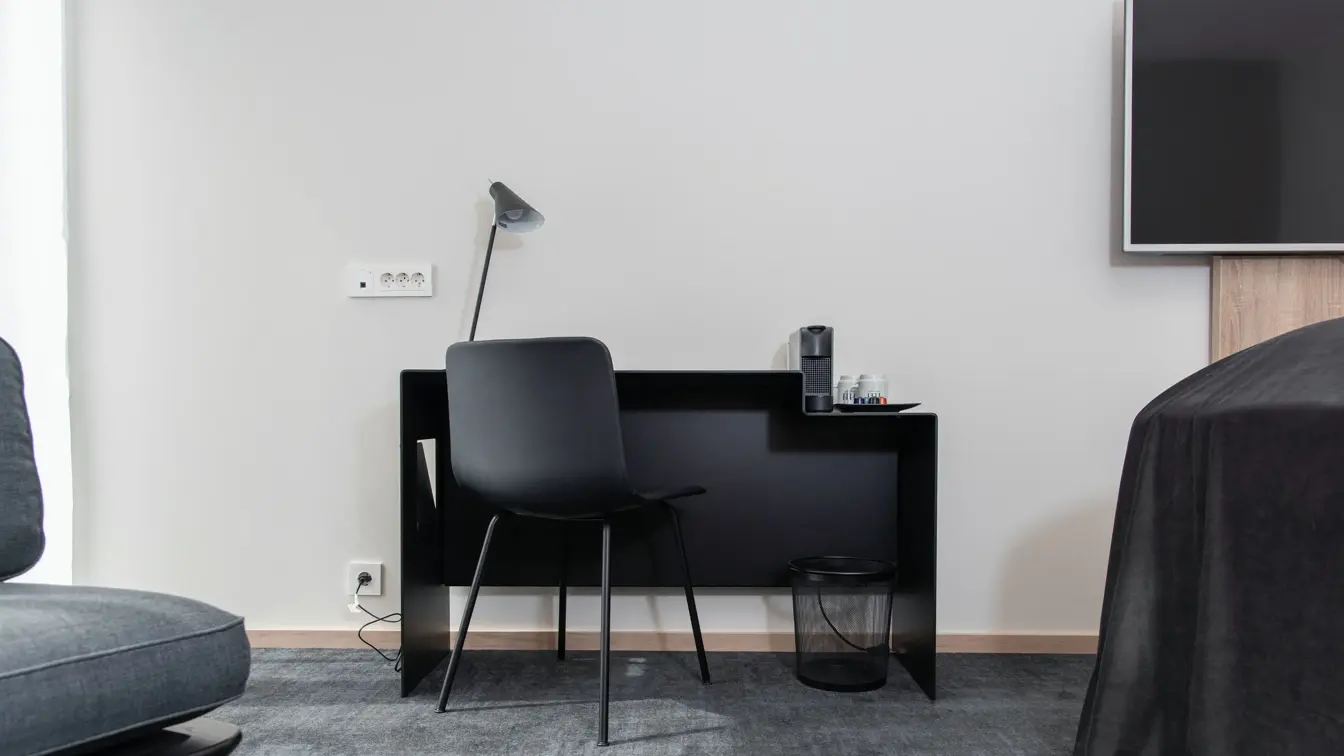 Sort skrivebord, stol og leselampe. Vegghengt TV.  I business rom på Thon Hotel Norge i Kristiansand
