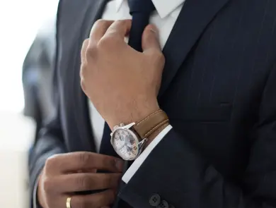 Mann i dress som justerer slipset sitt