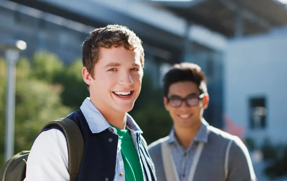 to unge gutter med ryggsekk, laptop og termokopp i hånden