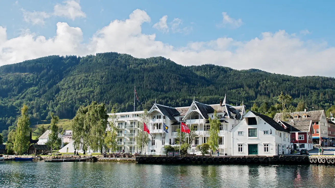 Fasade av Thon Hotel Sandven på sommeren med vann i forgrunnen 
