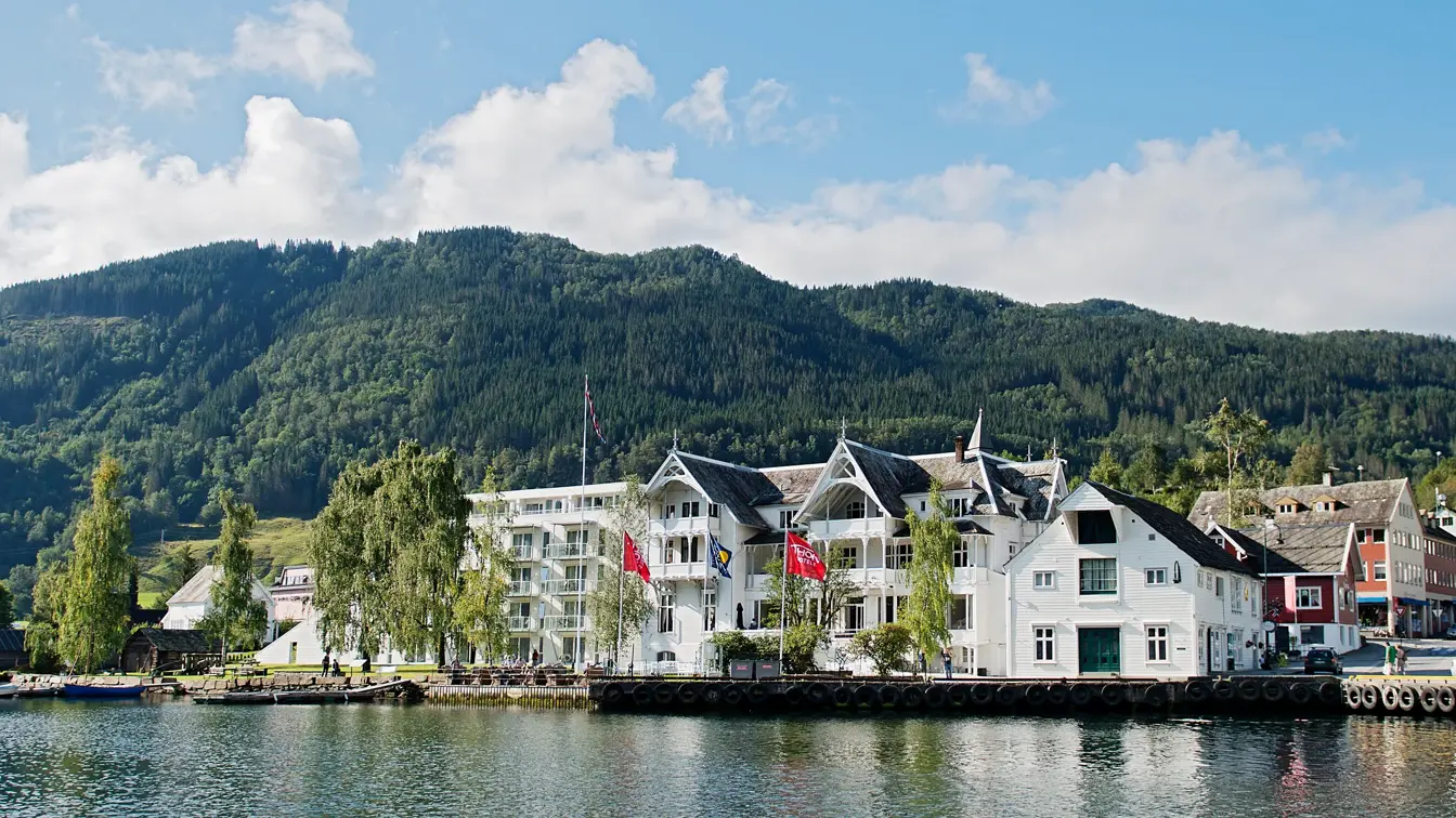 Fasade av Thon Hotel Sandven på sommeren med vann i forgrunnen 