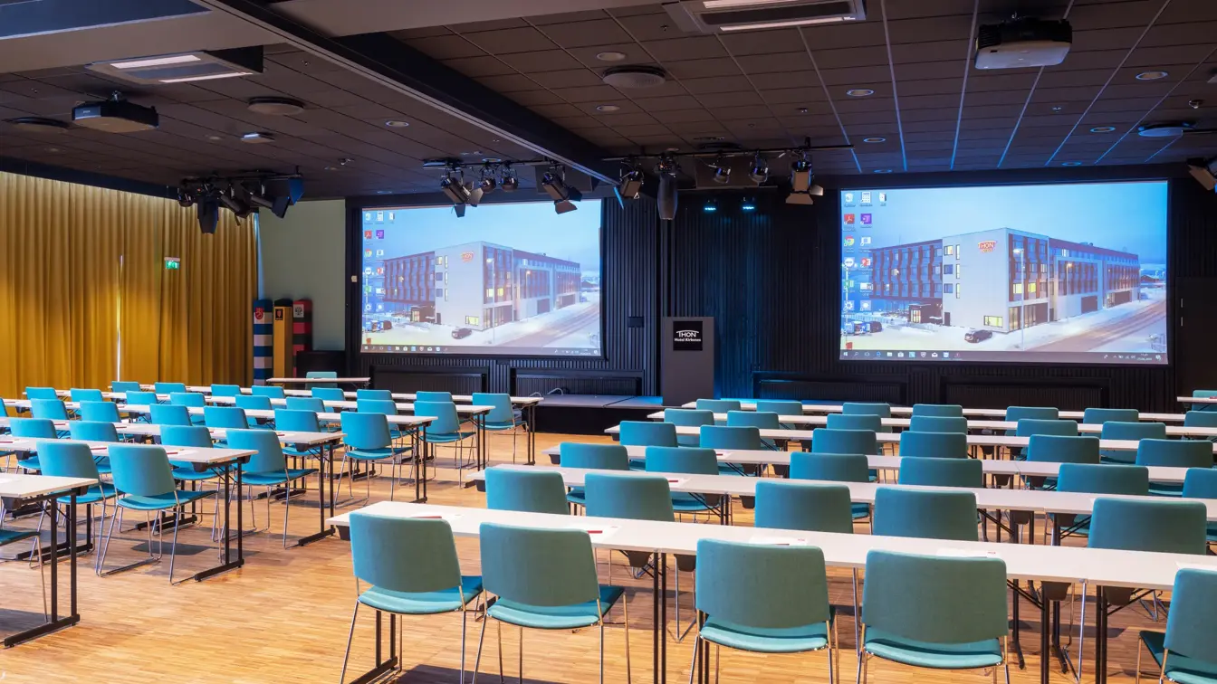 Turkise stoler og hvite bord i klasserom oppsett i konferanserom på Thon Hotel Kirkenes