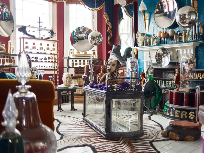 Eklektisk stue fullt av møbler og antikviteter