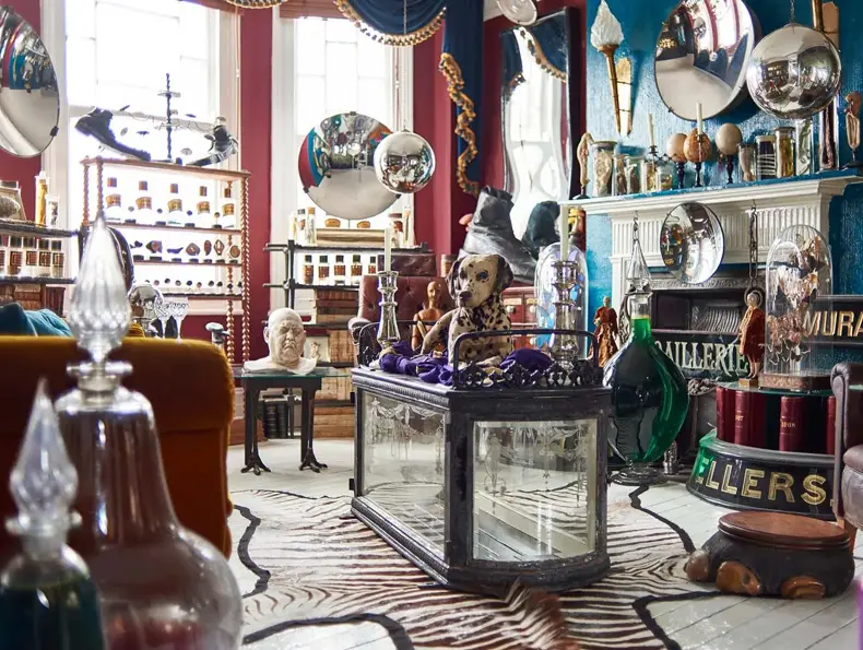 Eklektisk stue fullt av møbler og antikviteter