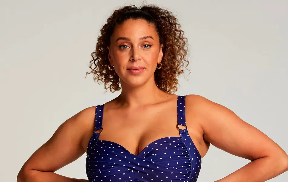 Modell i en blå og hvitprikkete badedrakt.