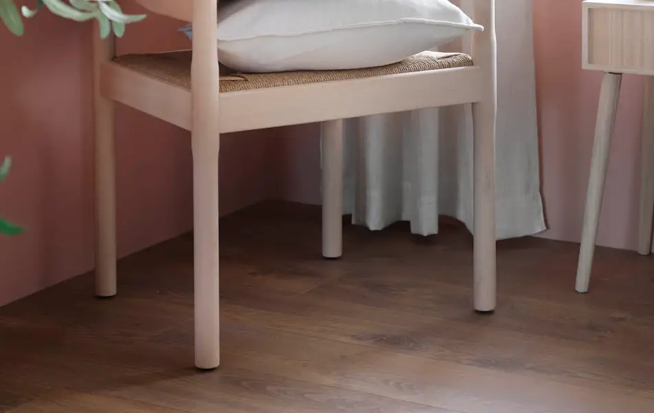 Stol med flere puter på i et rosa rom med gardiner.