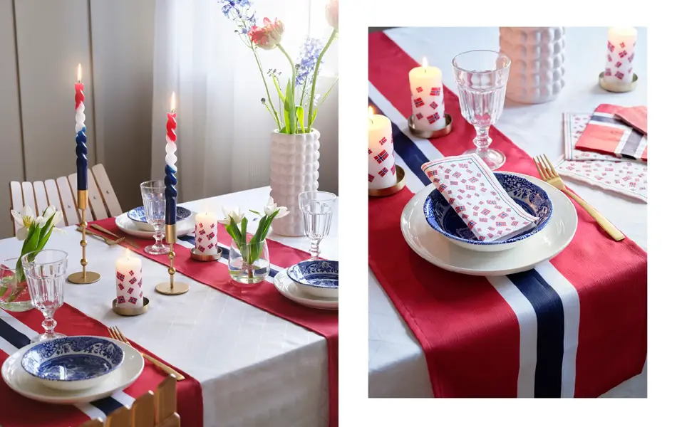 Bord med hvit duk, løper i flaggets fager, hvit tallerken, blå bolle, mønstret serviett, vinglass, lysestaker med rød, hvite og blå stearinlys, vase med blomster, kubbelys og små vaser med hvite blomster.